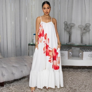 Detail of white floral sundress showing red flower print and ruffled hemline