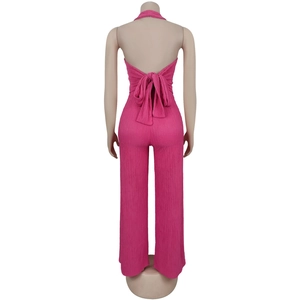 Detail view of the halter backless jumpsuit showing large bowknot and pleated fabric texture