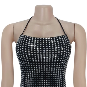 Close-up of black halter dress featuring dense silver square rhinestones and sleek fit