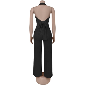 Detail of black halter jumpsuit showing open back design and waist tie ribbon