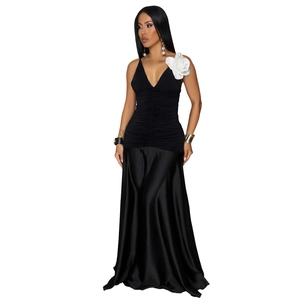 Detail of elegant black satin evening dress with deep V-neck and large white 3D flower decoration