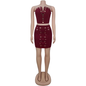Detail of dark red two-piece set featuring golden metal grommets on top and mini skirt