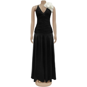 Detail of the elegant black satin maxi dress with a large white 3D floral accent on shoulder