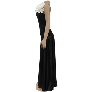 Detail of elegant black maxi dress with oversized white 3D flower on shoulder strap