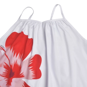 Close-up of white summer dress featuring thin straps, ruffled neckline and red hibiscus print