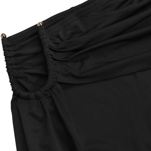 Détail du tissu froncé noir avec découpes et accents métalliques sphériques dorés