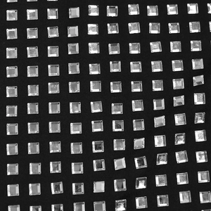 Macro detail of sparkling silver square rhinestones on high-quality black textile fabric