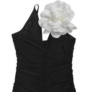 Detail of a black one-shoulder mesh bodysuit with a large 3D white flower on the strap