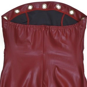 Dettaglio dell'abito in pelle PU bordeaux con grandi occhielli dorati e zip invisibile