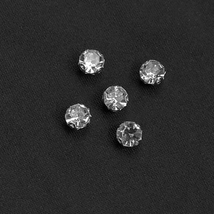 Close-up of sparkling rhinestone claw settings on elegant black fabric for dress detail