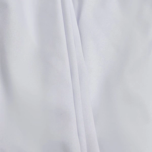 Close-up macro view showing the fine weave texture and soft folds of the white dress fabric