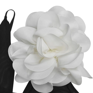 Detail of a large 3D white organza flower embellishment on a black mesh dress strap