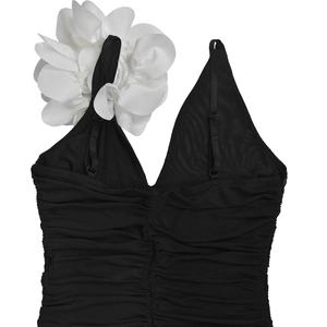Detail of black V-neck camisole top featuring 3D white fabric flower and ruched mesh texture