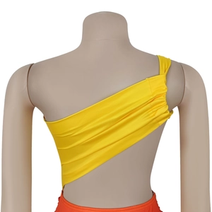 Détail du haut court jaune asymétrique montrant le dos plissé et la texture du tissu