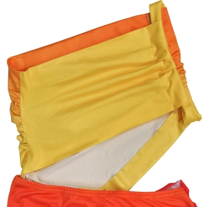 Détail du tissu de maillot de bain dégradé orange et jaune avec texture froncée sur le côté