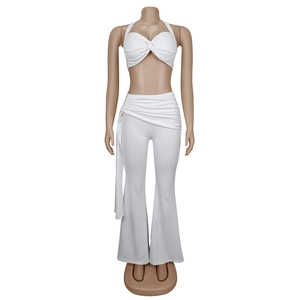 Détail d'un ensemble deux pièces blanc avec haut licou et pantalon évasé à rubans latéraux