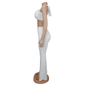 Détail d'un ensemble blanc deux pièces avec crop top licou et pantalon évasé taille haute