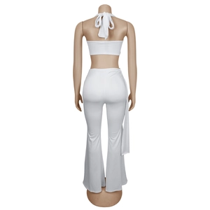 Détail du haut dos nu à licou avec nœud et pantalon évasé à taille haute blanc