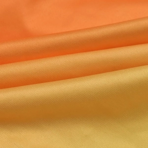 Vue détaillée du tissu satiné dégradé orange avec texture quadrillée et éclat soyeux