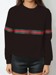 Détail d'un sweat-shirt noir à col rond orné d'un ruban rayé vert et rouge classique