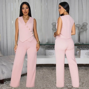 Détail du gilet rose sans manches avec boutons dorés et pantalon assorti à taille haute