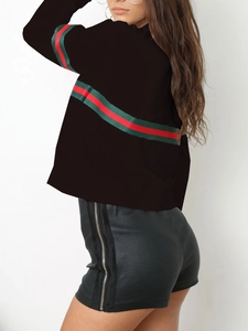 Détail du haut noir à manches longues avec rayures rouge-vert et zip latéral argenté