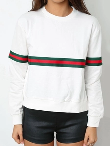 Détail d'un sweat-shirt blanc à manches longues avec bandes rouges et vertes sur les bras