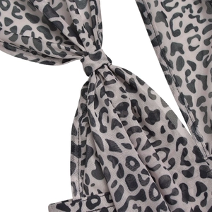 Detailed close-up of leopard print mesh fabric with elegant knot design on a jumpsuit