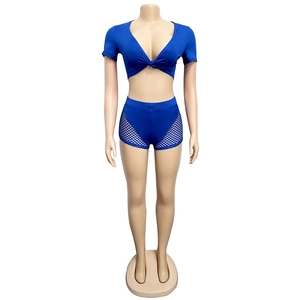 Detail of navy blue two-piece set featuring mesh patchwork and front-knot crop top design