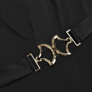 Close-up of elegant gold geometric buckles on the waist of a black summer jumpsuit
