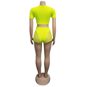 Neon yellow two-piece set with mesh side panels and high-waisted shorts on mannequin