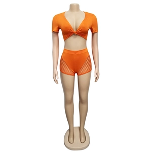 Detailed view of orange two-piece set featuring mesh paneling and front knot top design