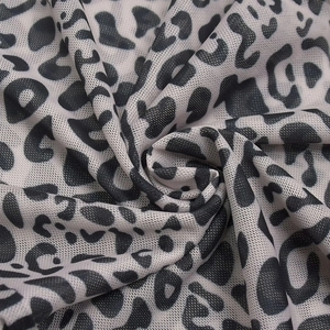 Macro shot of breathable leopard print mesh fabric with grey and black spotted patterns