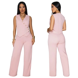 Détail du gilet rose sans manches à col en V avec boutons dorés et pantalon large