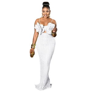 Detailed view of 3D floral corsage on white lace camisole top and knit maxi skirt