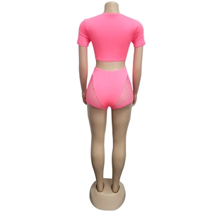 Detailed back view of neon pink crop top and high waist shorts with side mesh panels