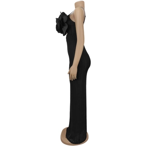 Detail of a black backless maxi dress with a 3D floral accent on the chest area