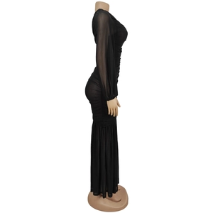 Detail of sheer black mesh fabric and bodycon silhouette on a long sleeve dress