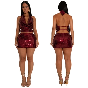 Détail de l'ensemble pailleté rouge foncé avec haut dos nu et mini-jupe moulante brillante