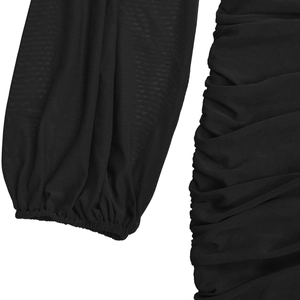 Detailed view of sheer mesh ruched fabric and puff lantern sleeves on a black dress