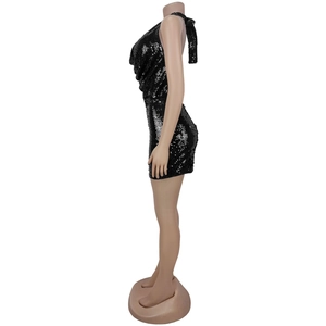 Détail de la mini-robe à paillettes noires montrant le dos nu et la texture métallique