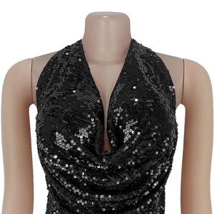 Détail d'un haut dos nu à paillettes noires avec col en V profond et tissu drapé