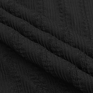 Macro detail of black ribbed knit fabric texture with waffle pattern for dress