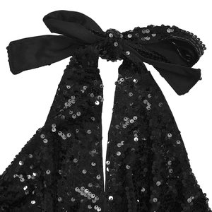 Détail du haut dos nu à paillettes avec élégant nœud en satin noir attaché au cou