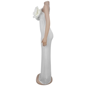 Detail of elegant white bodycon maxi dress featuring a large 3D floral accent on the chest