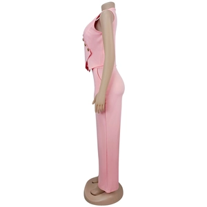 Détail du gilet de costume rose sans manches montrant des boutons dorés décoratifs