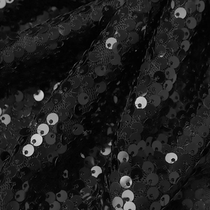 Détail de sequins noirs scintillants cousus sur un tissu en maille pour vêtements