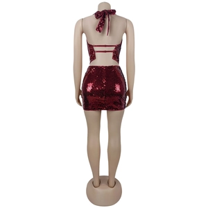 Détail de la texture à paillettes bordeaux sur le haut dos nu et la mini-jupe assortie