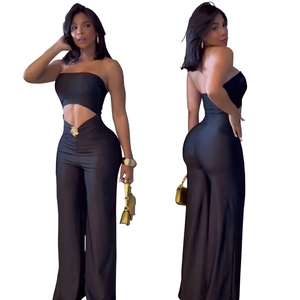 Detail of black cut-out jumpsuit featuring gold metal disc and wide-leg design