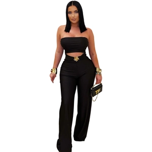 Detail view of high-waist black jumpsuit with gold spiral hardware and trendy accessories